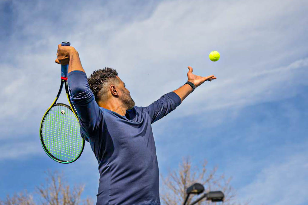 man serving a tennis ball
