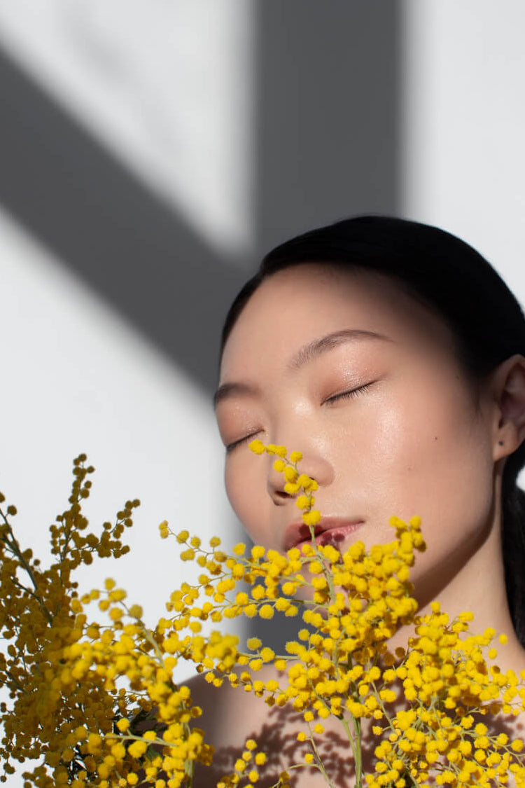 beautifulasianwomanposingholdingyellowflowerswithperfectskin1