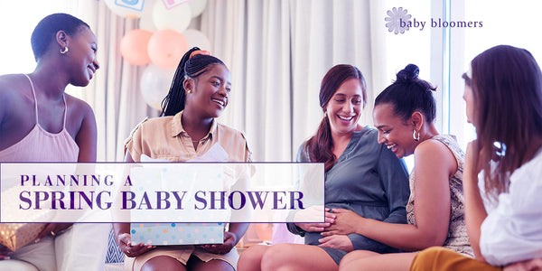 Women laughing and opening presents at a spring baby shower celebration. | Baby Bloomers