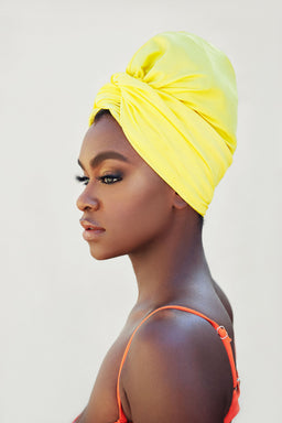 Model wearing a swim turban to shield hair from chemicals such as chlorine and salt