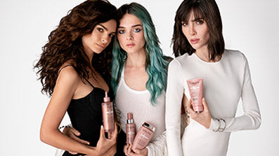 Three models pose holding Kerastase Chroma Absolu products