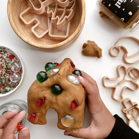 Hands holding Sensory Dough from Handful Dough Co. Background white with cookie cutters