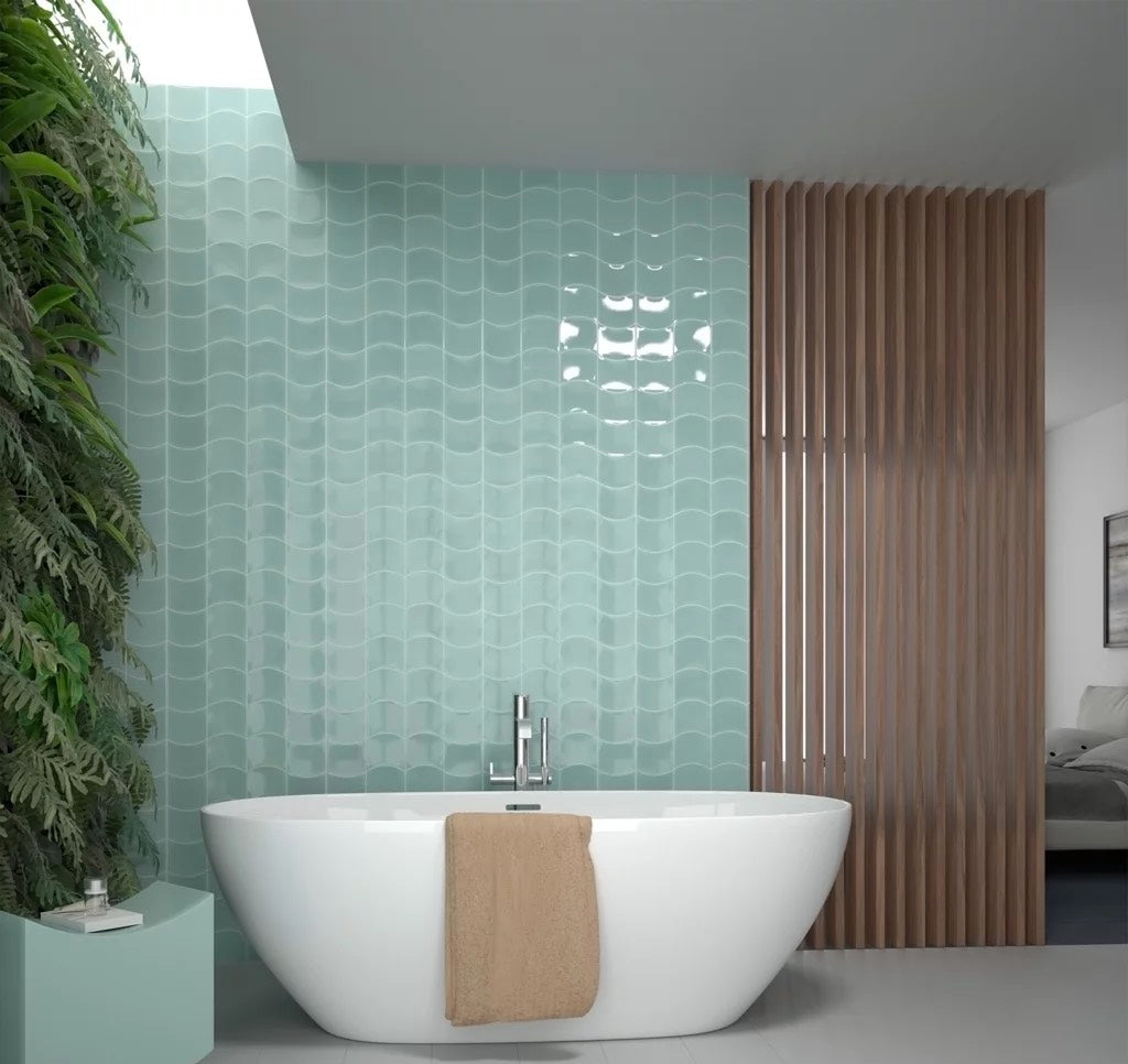 Wave-like mint green tiles behind a bath