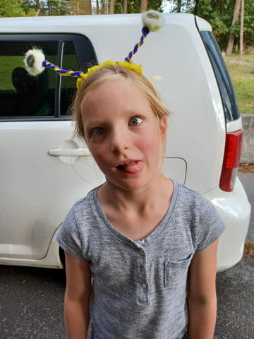 A young student wears Eyeball Costume Headband made from pipecleaners and wool