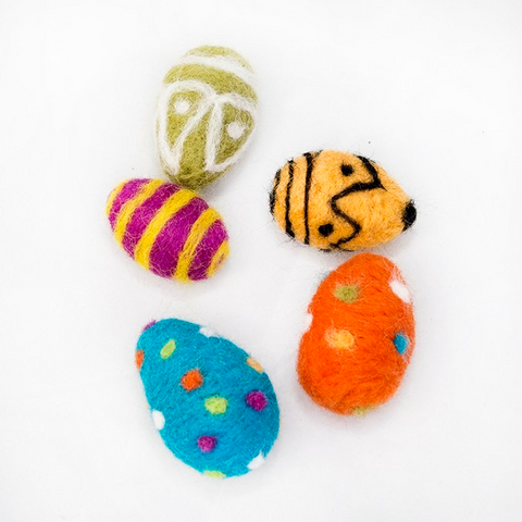 4 colorful felted easter eggs on a white background. Clockwise from top: olive green with a white triangle pattern, yellow with a black triangle charlie brown pattern, orange with multi colored polka dots, teal blue with multi colored polka dots and magenta with yellow stripes