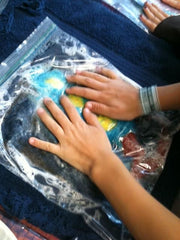 close up of hands wet felting wool inside a ziplock bag