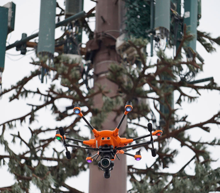 Camera-mounted drone for workplace inspection flying over a park