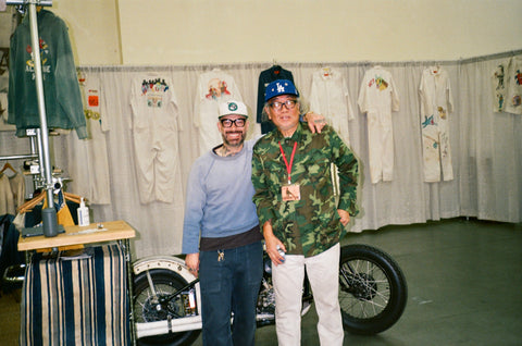 Excel and friend standing next to the ATH booth in front of his knucklehead harley davidson motorcycle