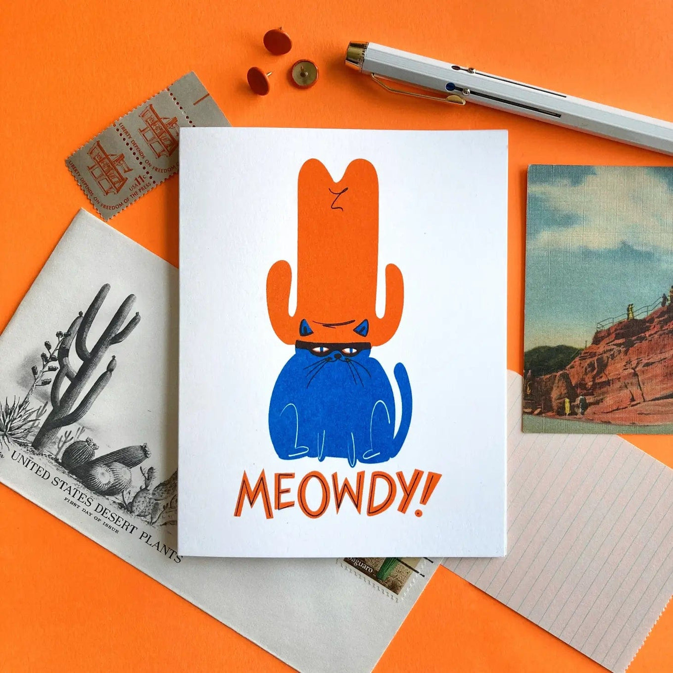 A drawing of a blue cat with an orange cowboy hat. 