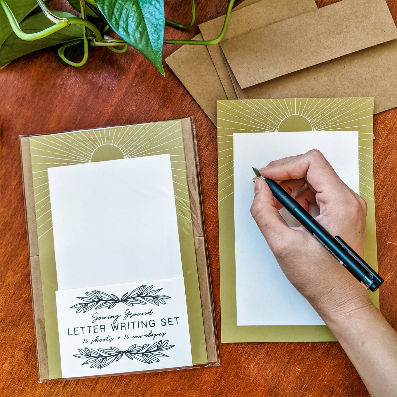 A hand writing on white stationery with a yellow sunbeam border. 