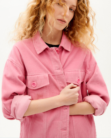 Blonde woman in a pink shirt jacket