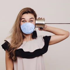 woman with mask on using hearing amplifier