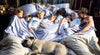 Eight people and two pets all sleeping together in the same bed