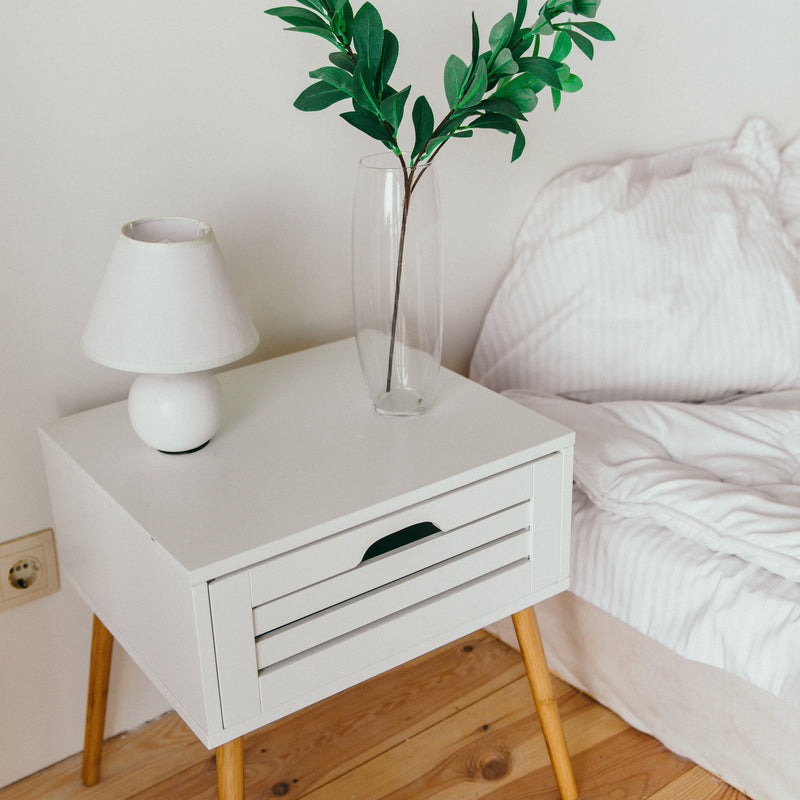 Home Polyester Pillow in pillow sheet placed in a clean bedroom with wood accents and side table in focus