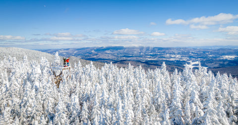 Bolton Valley fire towner standing above a snow covered mountain forest