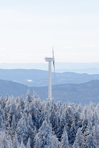 Windmill above the snow covered trees and mountains of Vermont