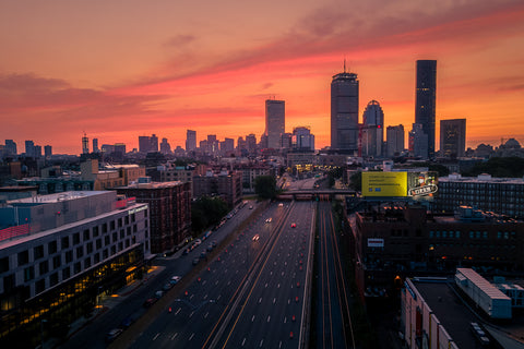 Boston skyline at sunrise, with an empty Mass Pike in front of it