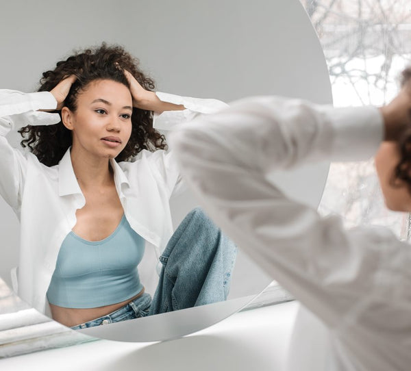 Woman checks for puffy eyes in the morning and will use trixsent therapy oils by athena klee for solve