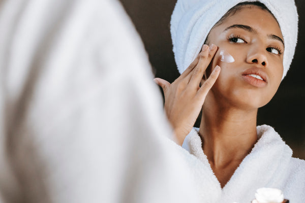 woman cleans face with cotton swab before using trixsent therapy oils to heal her winter weather damaged skin