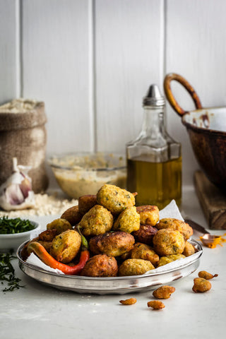 Plate of Corn Bhajees, Deep fried Indian snack, oil, dirty wok, garlic bulb, chopped fenugreek, mixture in the background