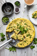 Gujarati Dhokla in thali, sliced in a plate with cup of chai, tadka of mustard seeks and chopped coriander and coriander chutney to serve with