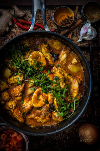 Chicken Curry, Gujarati Soupy Chicken in frypan topped with fresh coriander and spring onions