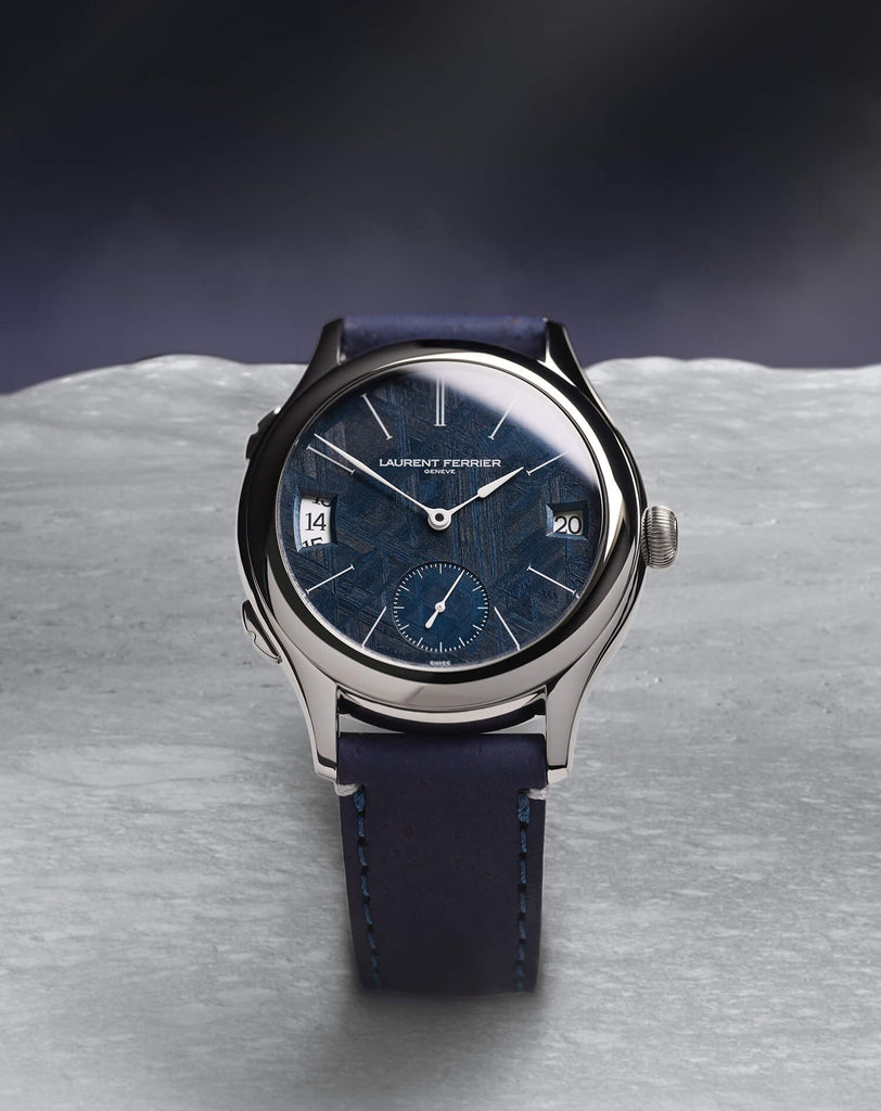 Laurent Ferrier "Météorite" 15-piece limited edition standing straight on what looks like the moon landscape. The fine watch features a real deep blue navy meteorite dial and a navy blue cork strap bracelet. Photography Cyril Biselx
