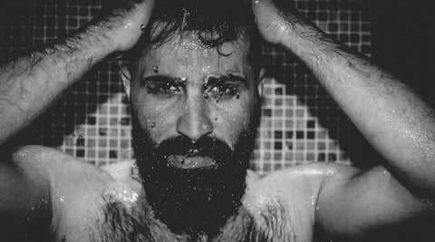 Bearded man washing his face and beard