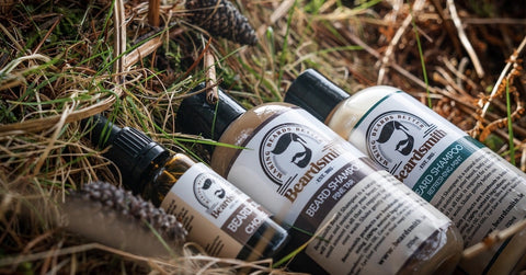 Bottles of beard shampoo and beard oil in the grass