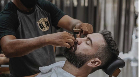 Barber trimming a beard