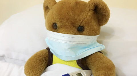 Teddy bear with thermometer and face mask