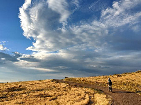 a rider on a gravel path at sunset