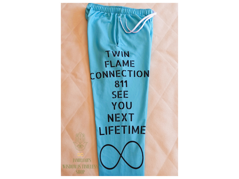 Jamilliahs Wisdom Is Timeless Shop merchandise, shown with hamsa hand/infinity symbol logo, at wisdomistimeless.com. Women's blue joggers with infinity symbol design and original quote. "Twin Flame Connection 811, See You Next Lifetime."