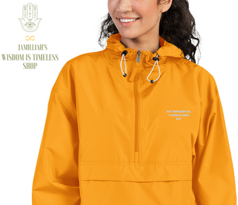 Jamilliahs Wisdom Is Timeless Shop merchandise, shown with hamsa hand/infinity symbol logo, at wisdomistimeless.com. Champion brand, gold, embroidered, packable, unisex, jacket; with original quote. "My Immortal Twin Flame 811."