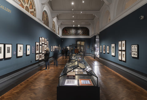 Dark navy walls with paintings at the V&A museum, London