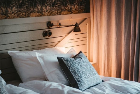 Bed, lighting and textured cushions
