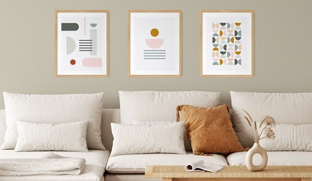 White sofa with three framed contemporary Tall Boy Prints designs on wall