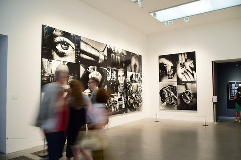 People walking past black and white photography prints at the Tate Modern