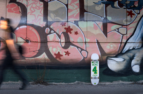 Pink graffiti wall with white and green skateboard in Helsinki, Finland