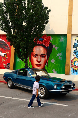 Graffiti art portrait of Frida Kahlo with blue car 