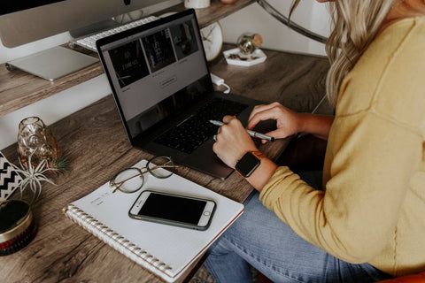 Girl in yellow jumper working hard at desk on her laptop