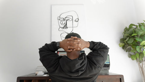 Man sitting in office chair looking at a contemporary art print hung on the wall