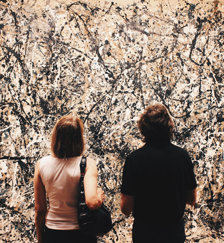 Woman and man standing looking at famous US art by Jason Pollock