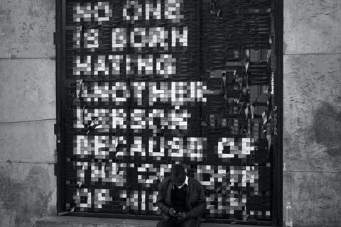 Blurred, pixelized text graffiti on plain black wall in Paris, France