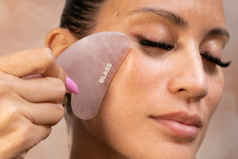 woman using Blass Gua Sha on cheek