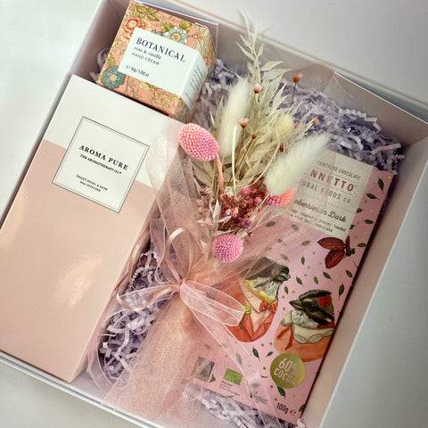 Pink gift box with rooms scent, hand cream, chocolate and flowers