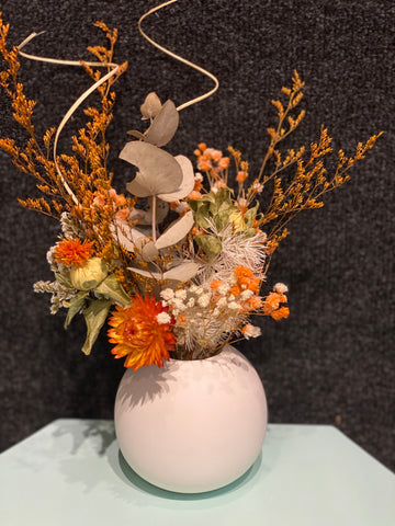 Dried flowers in orange theme in ceramic vase