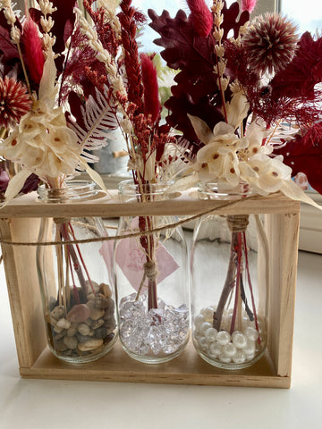 Milk bottles in a tray with dried flowers