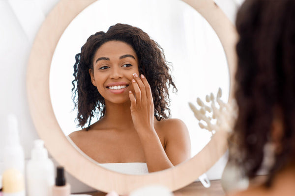 woman smiling while staring at the mirror 