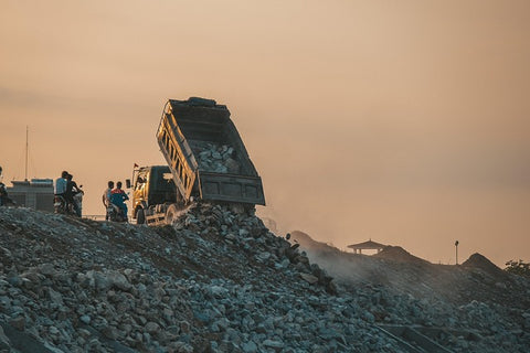 image of garbage truck dumping in landfill in developing country